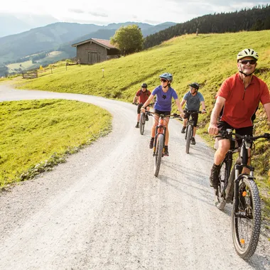 Ihr Mountainbike Urlaub Gruppe von Radfahrern auf Mountainbikes auf einem Schotterweg durch eine idyllische Landschaft